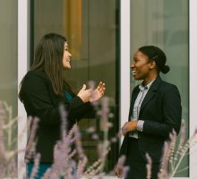 Two LL.M. students having a conversation in front of Dineen Hall.